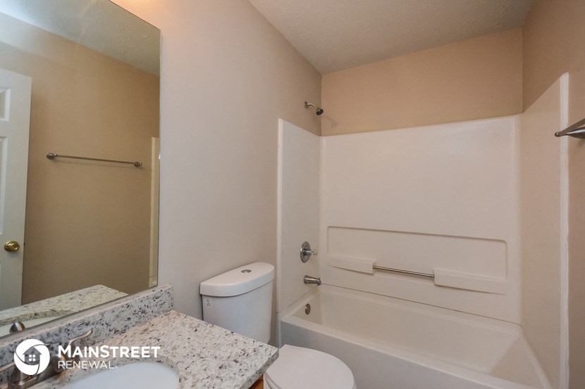 a bathroom with a tub and a sink and a toilet