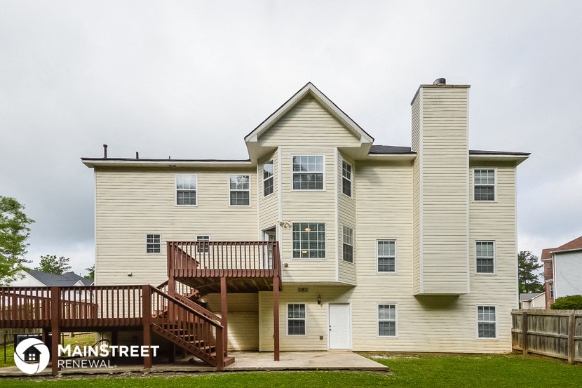 a large white house with a deck on the side of it