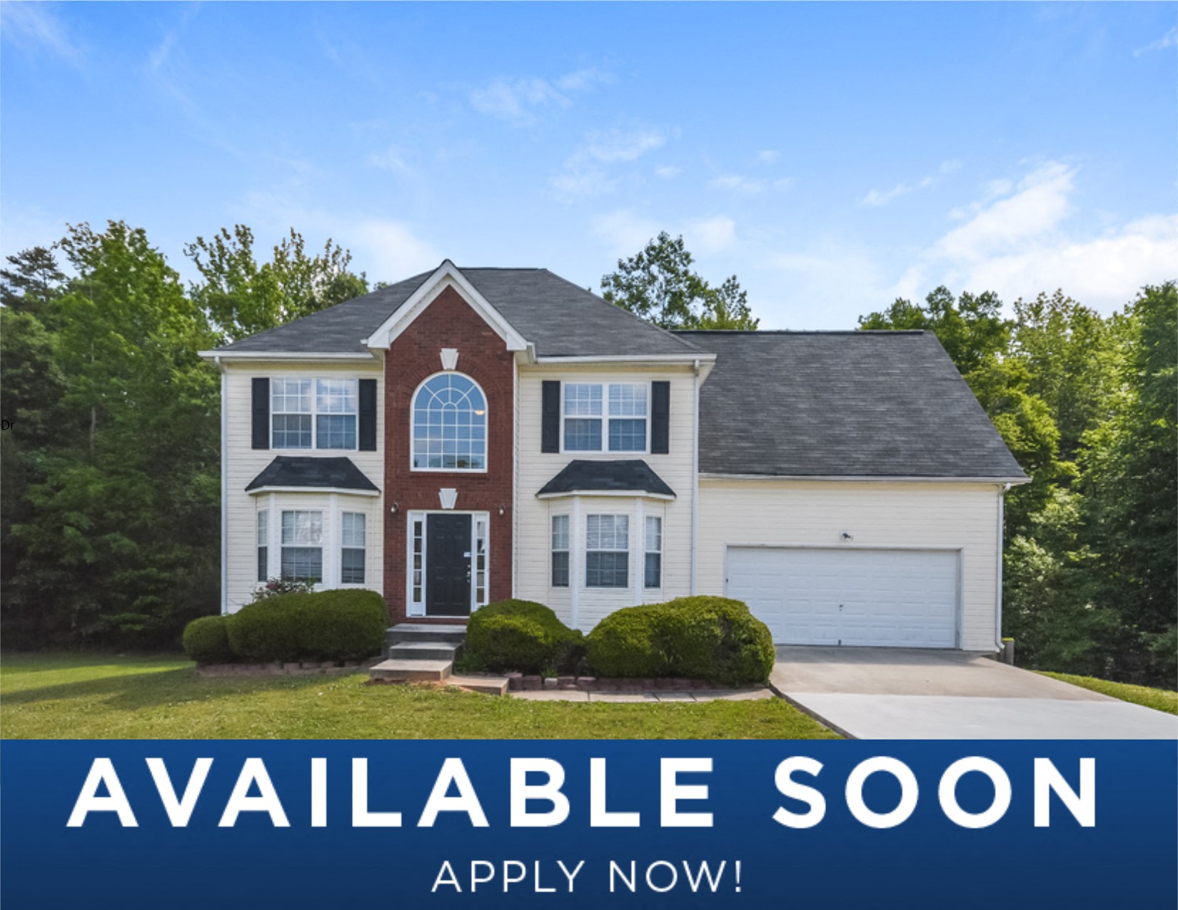 a white house with a black roof and a lawn