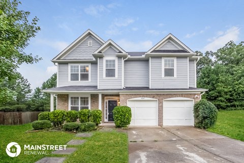 a blue and white house with two garage doors