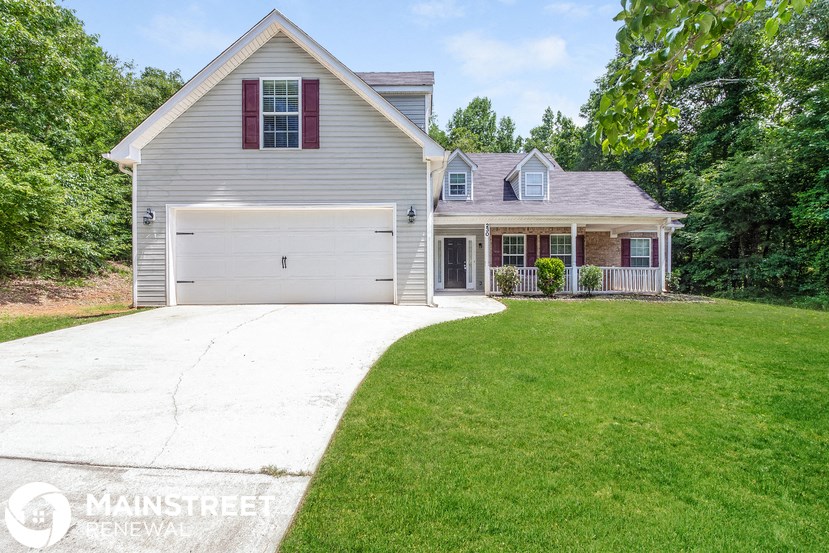 a white house with a driveway and a lawn