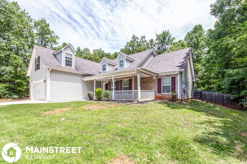 a white house with a yard and a wood fence