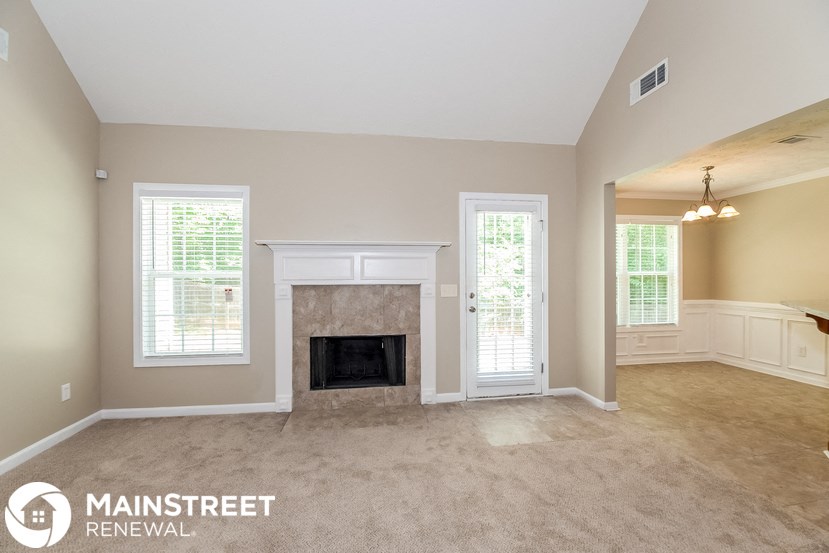 an empty living room with a fireplace and a window