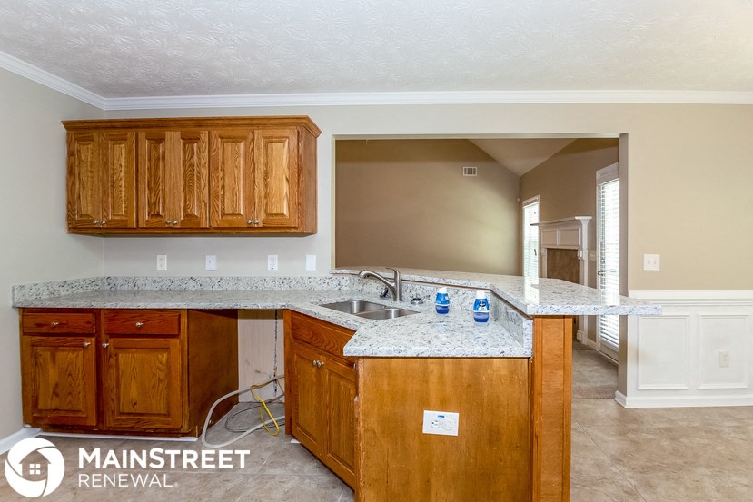 a kitchen with wooden cabinets and granite counter tops