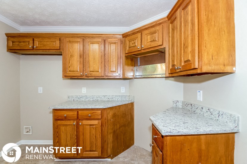 a kitchen with wooden cabinets and granite counter tops