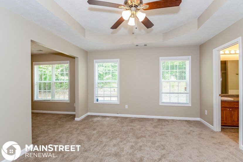 the living room of an empty house with a ceiling fan