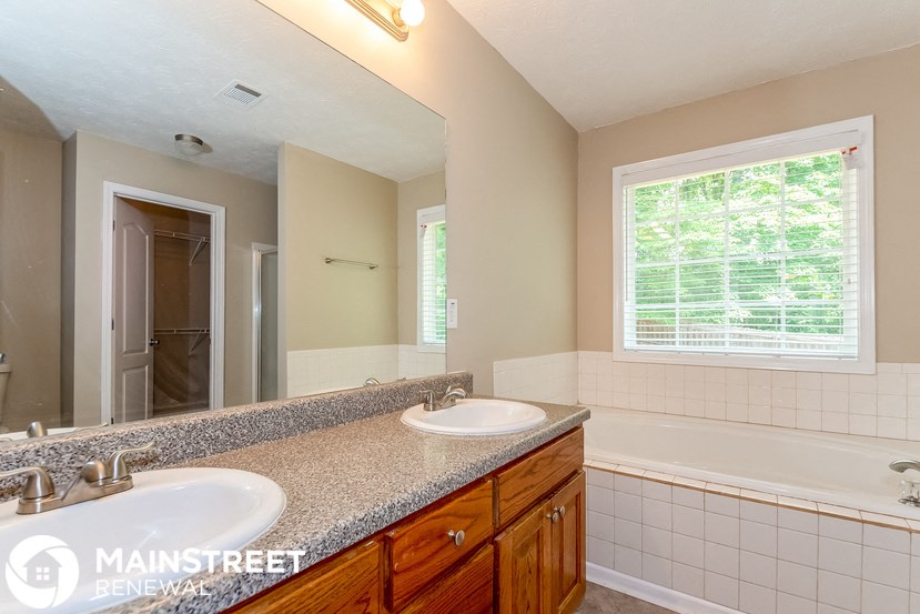 a bathroom with two sinks and a tub and a mirror