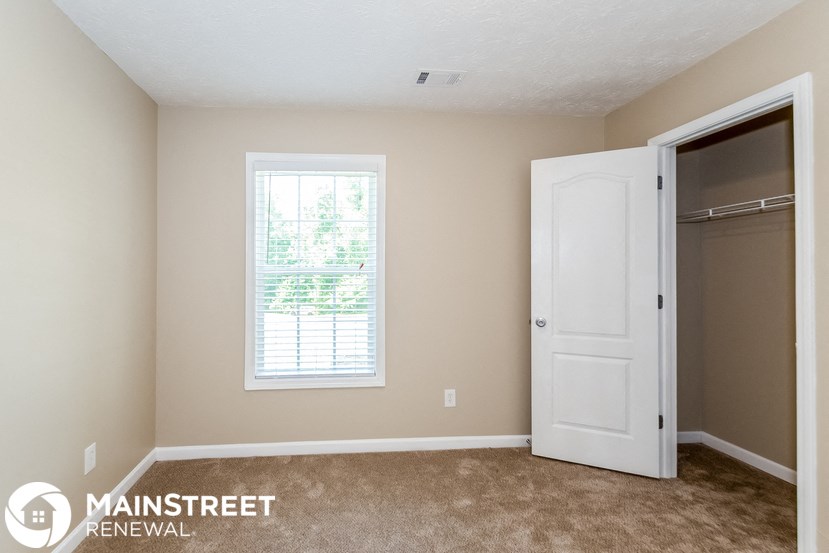 a bedroom with a closet and a window and a door