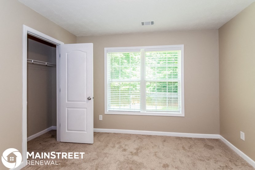 a bedroom with a large window and a closet