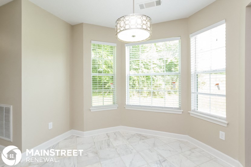 a room with three windows and a marble floor and a chandelier