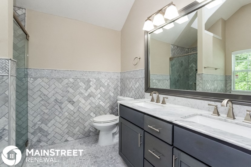 a bathroom with a toilet and a sink and a mirror