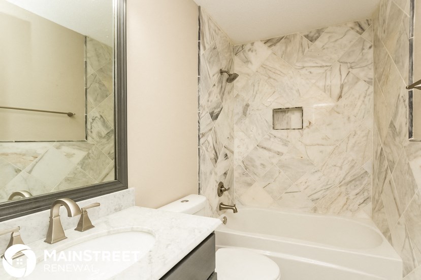 a bathroom with a tub and a sink and a mirror