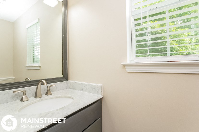 a bathroom with a sink and a mirror and a window