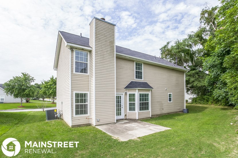 a small house with a tall tower on top of a grass covered yard