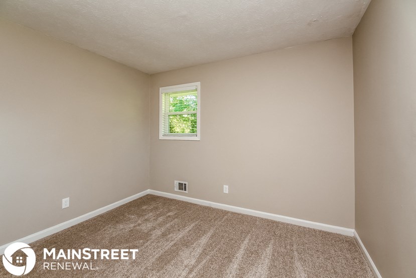 the upstairs bedroom has carpet and a window
