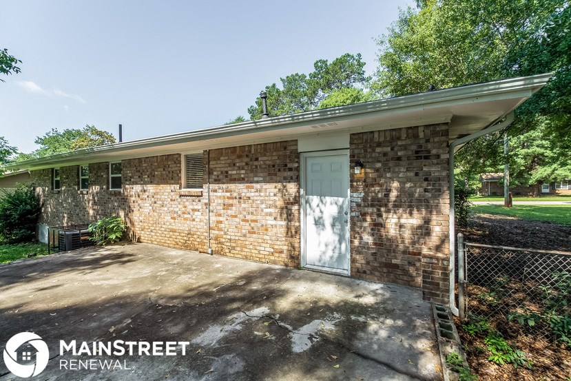 the front of a brick house with a blue door