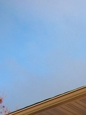 a yellow house with a balcony and a blue sky