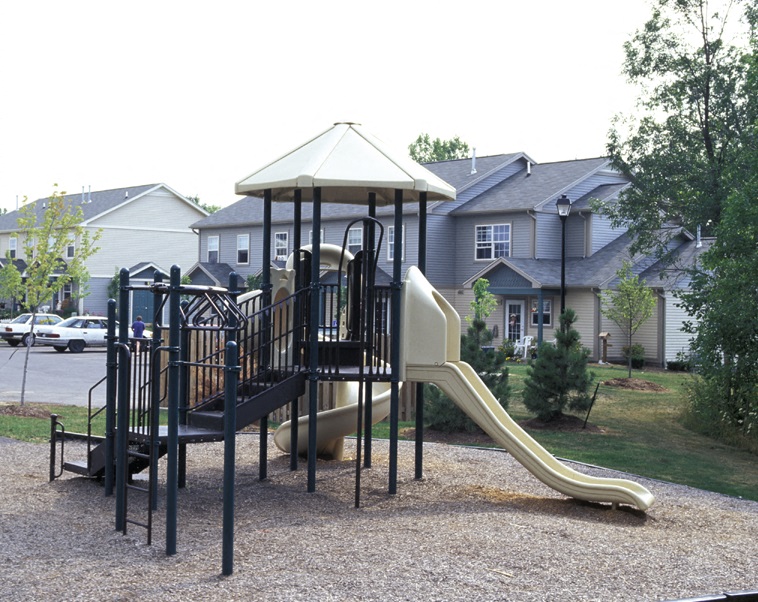 A playground with a slide and a swing set.