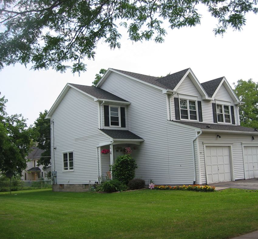 a white house with white siding and white garage doors