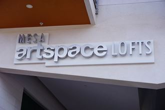 a sign for mesa artspace loft on the side of a building