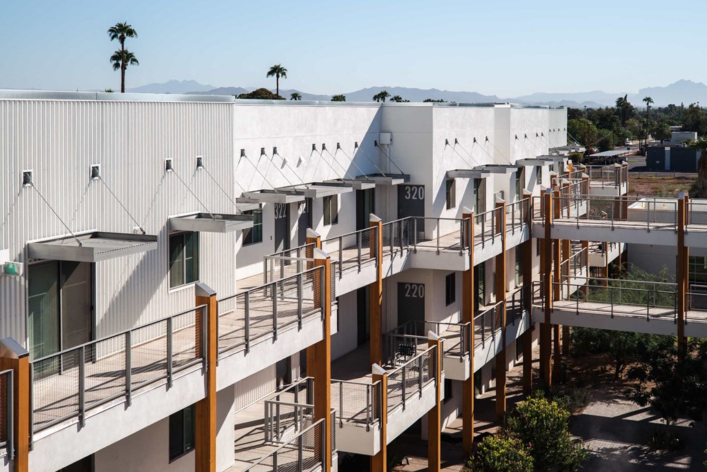 a group of buildings with balconies in front of a city