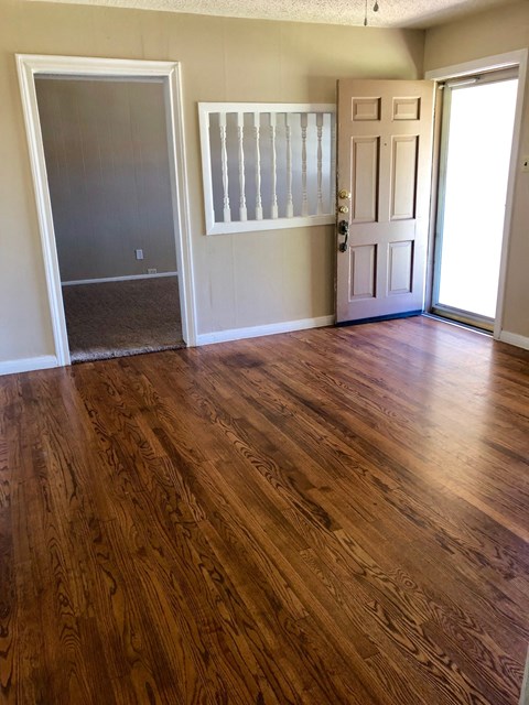 A room with a wooden floor and a white door.