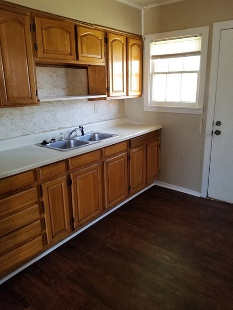 A kitchen with wooden cabinets and a white sink.