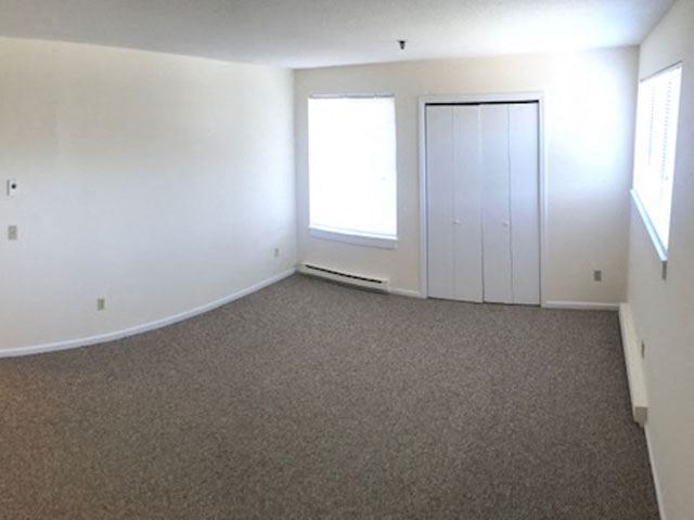 an empty living room with white walls and a window