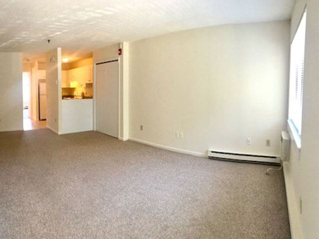 an empty living room with white walls and carpet