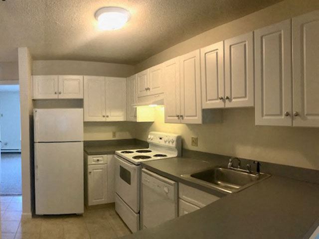 a kitchen with white appliances and white cabinets