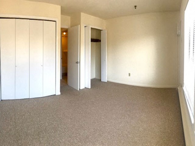 an empty living room with white walls and carpet