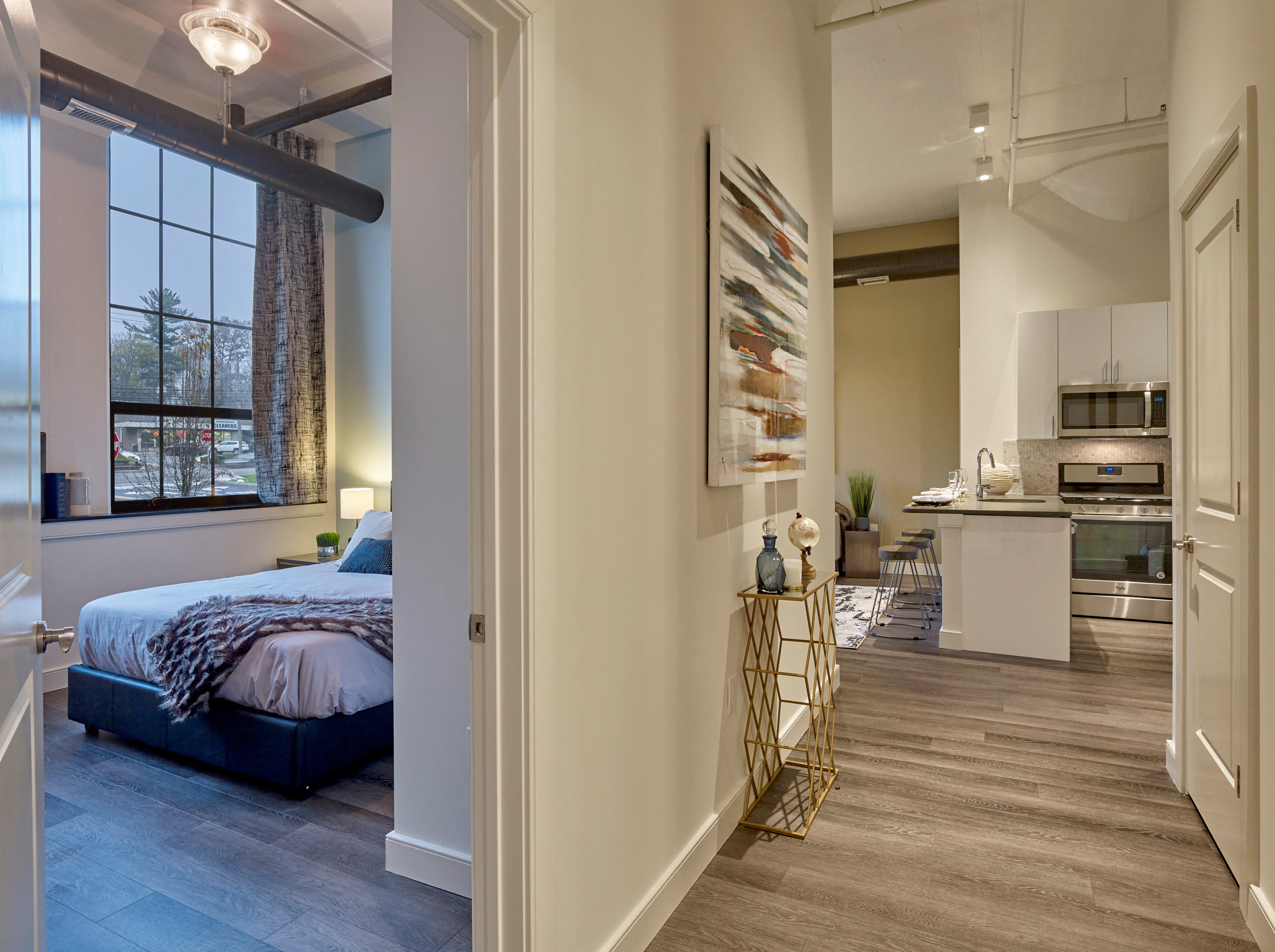 a view of a bedroom and a kitchen from a hallway