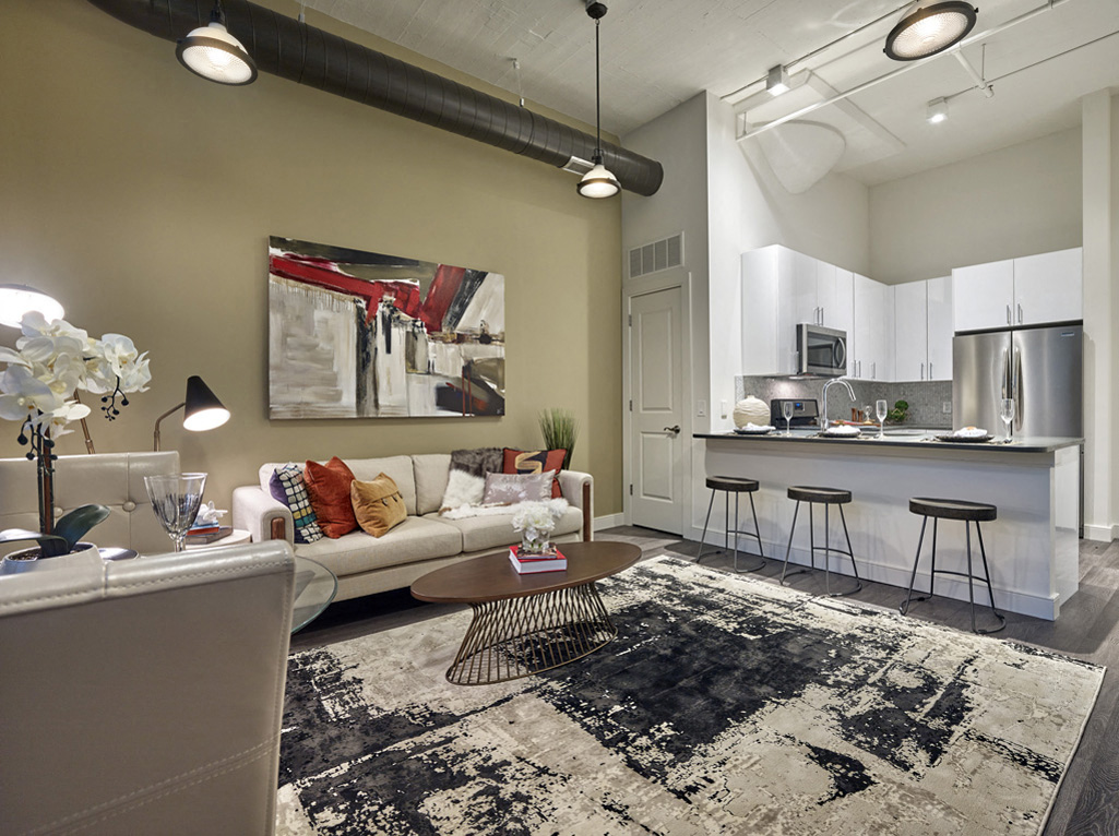 a living room with a couch and a kitchen with a bar