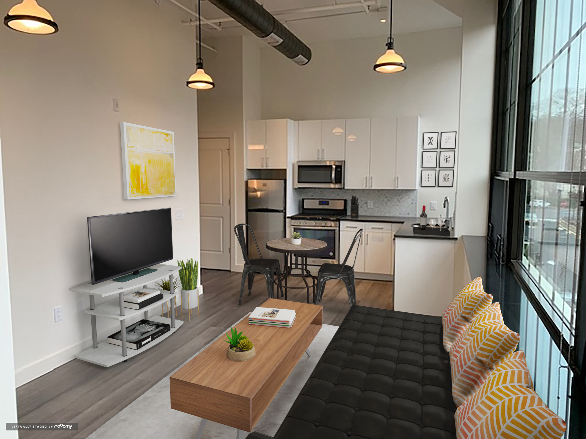 a living room with a couch and a tv in front of a kitchen