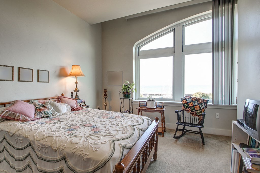 a bedroom with a bed and a large window