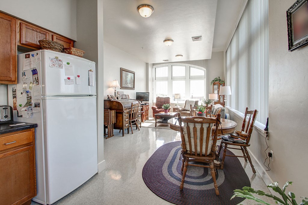 a kitchen and living room with a refrigerator and a table