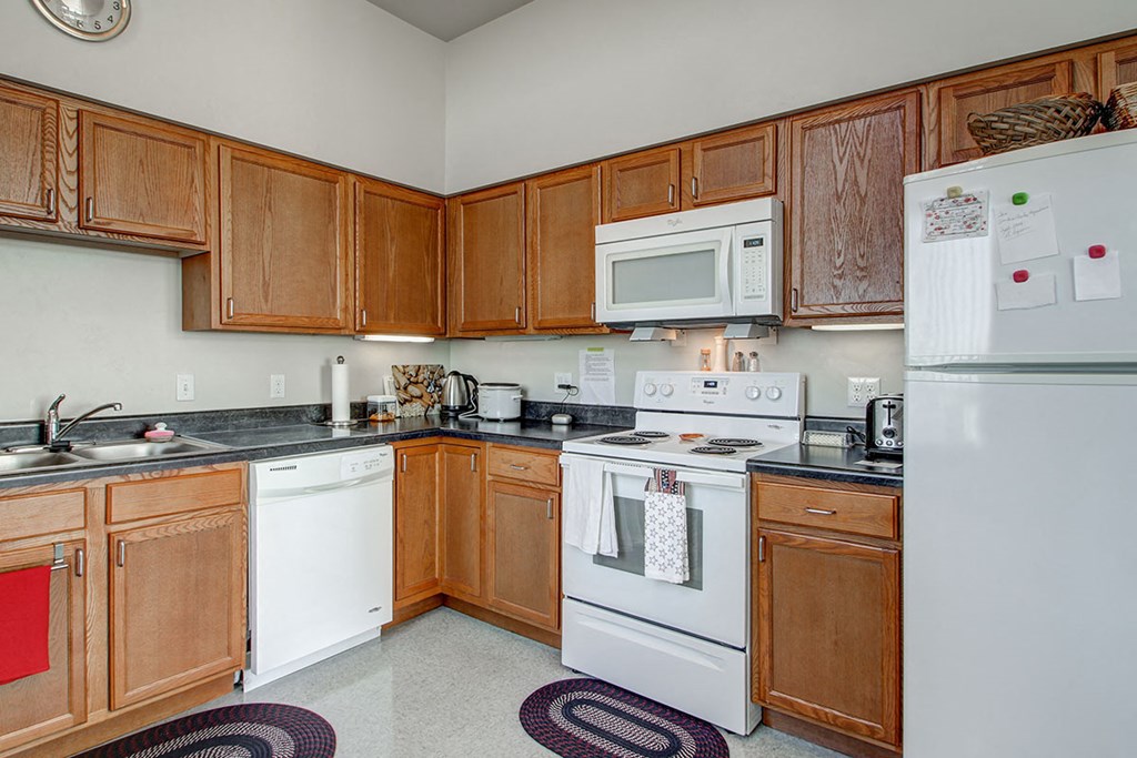 a kitchen with white appliances and wooden cabinets