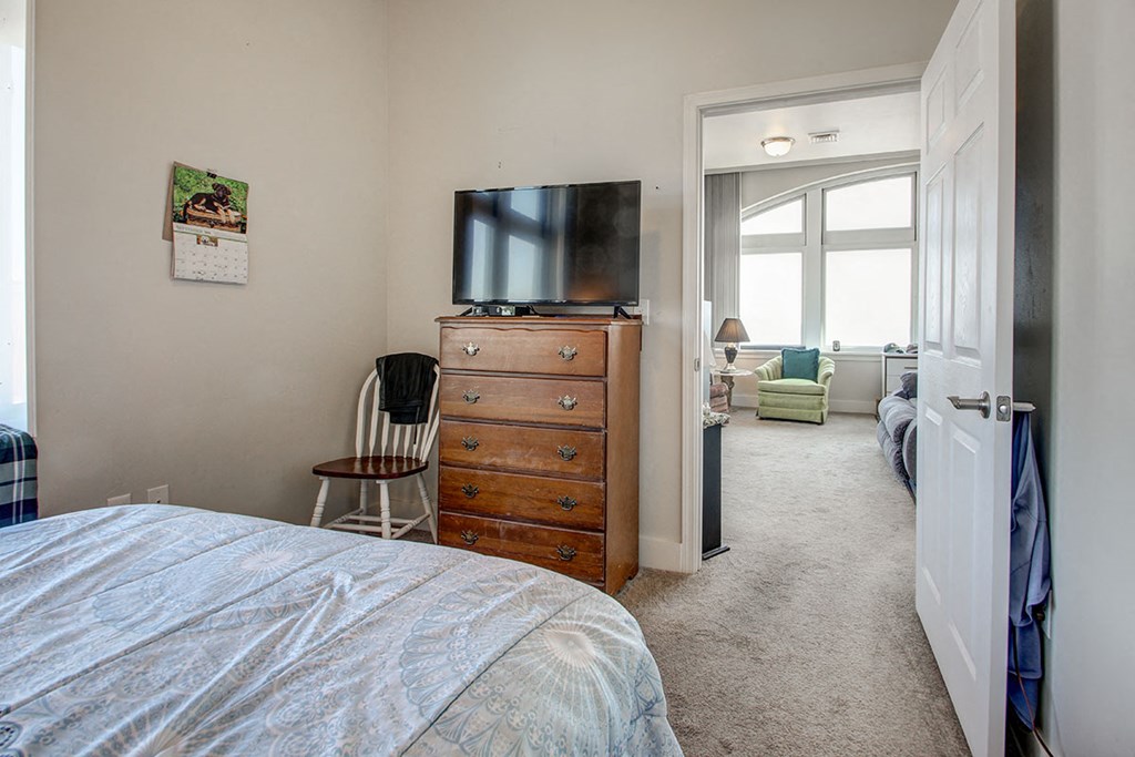 a bedroom with a bed and a television on top of a dresser