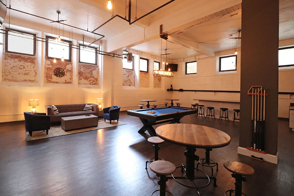 a game room with a pool table and tables