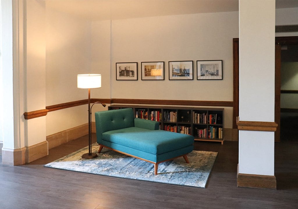 a living room with a blue couch and a book shelf