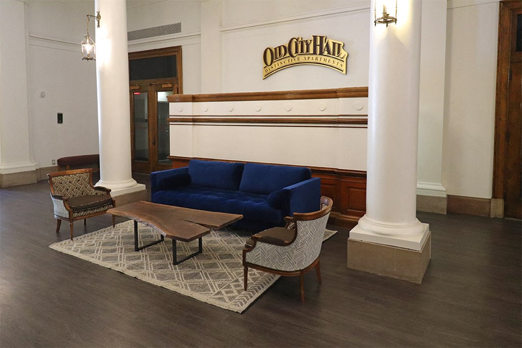a seating area with a blue couch and chairs in a lobby