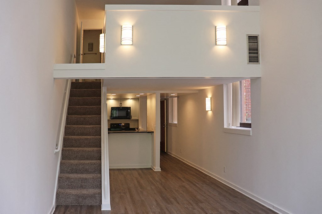 a view of a living room with a staircase and a kitchen