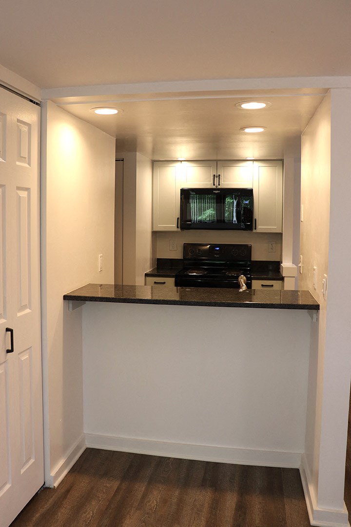 an empty kitchen with a counter top and a microwave