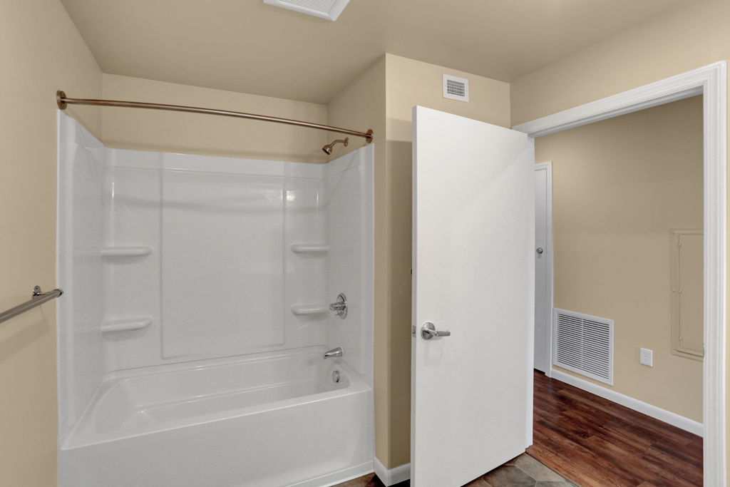 a bathroom with a white shower and a white door