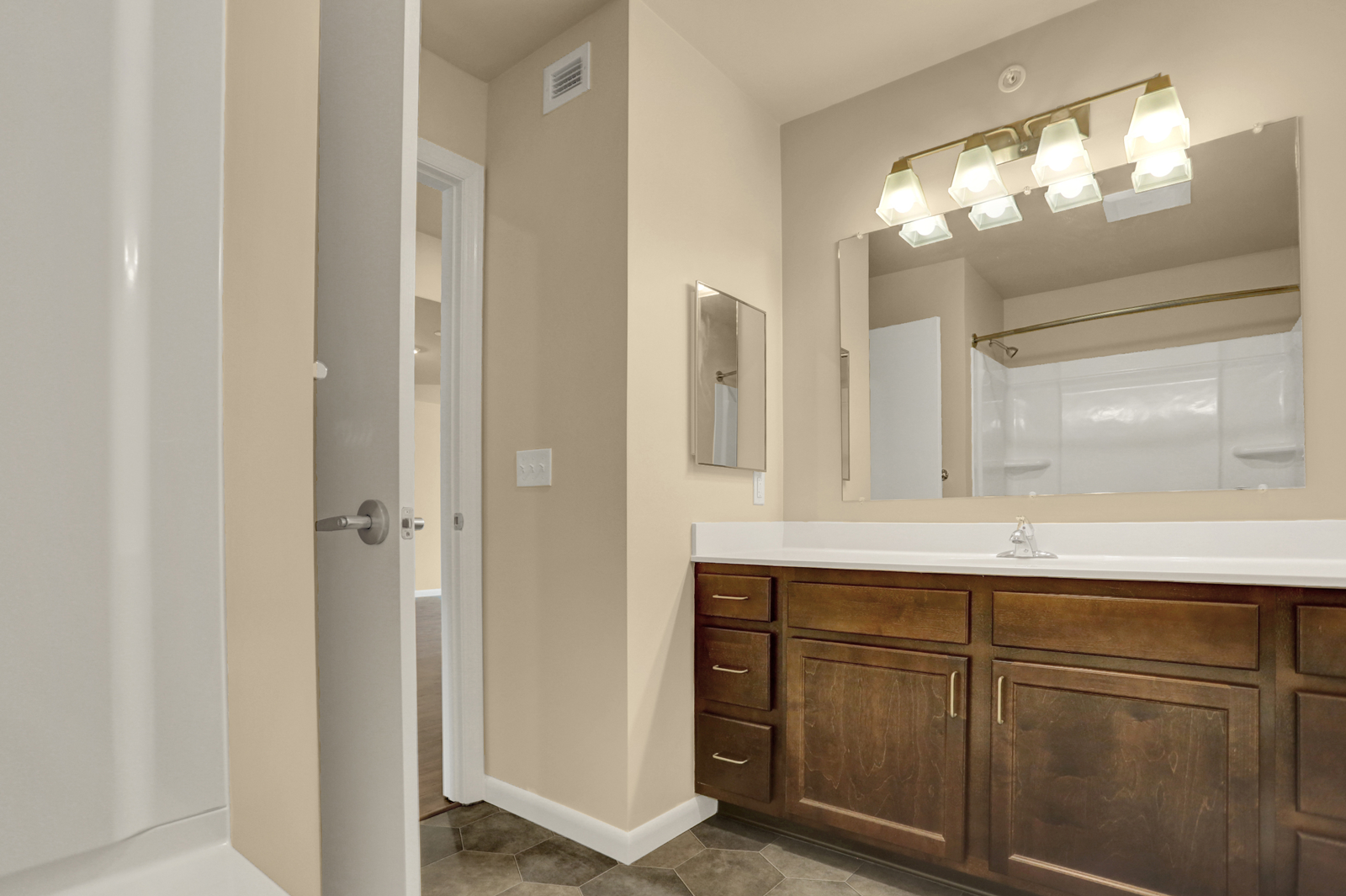 a bathroom with wooden cabinets and a mirror and a sink