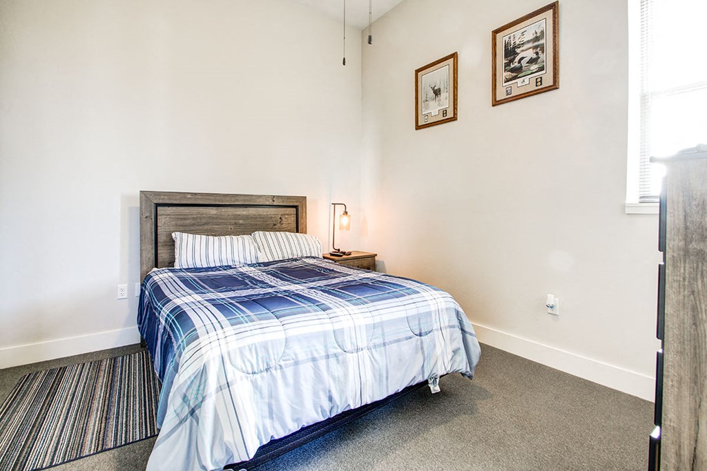 a bedroom with a bed and two pictures on the wall