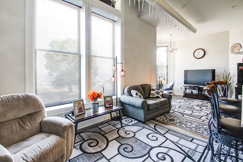a living room with a couch and a chair and a tv