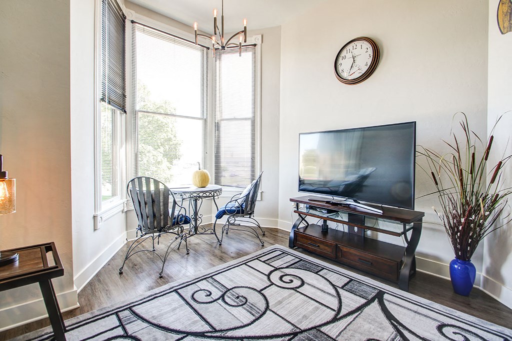 a living room with a tv and a table and chairs