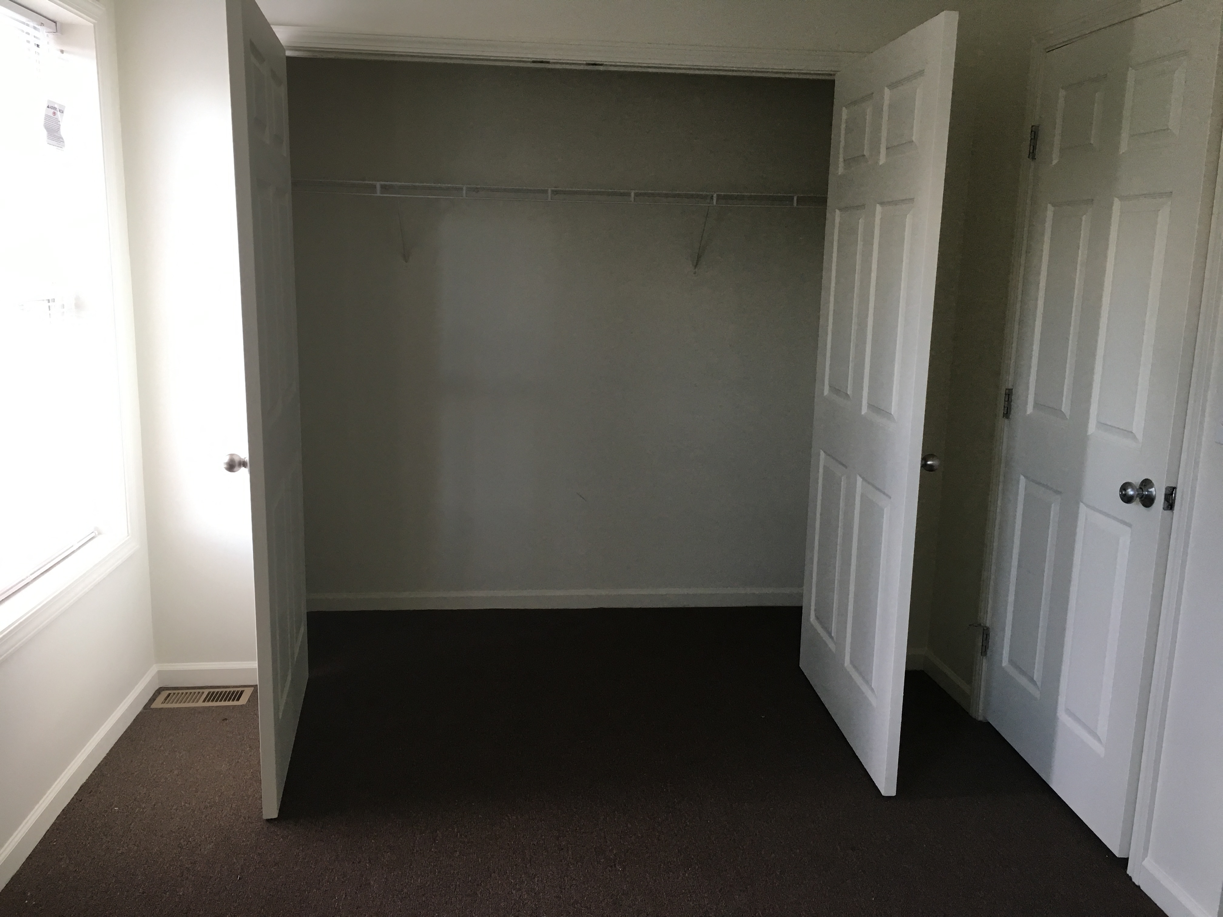 an empty room with a closet and a door