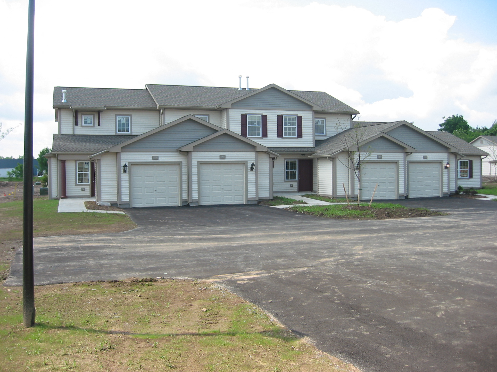 a white house with white garage doors and a driveway